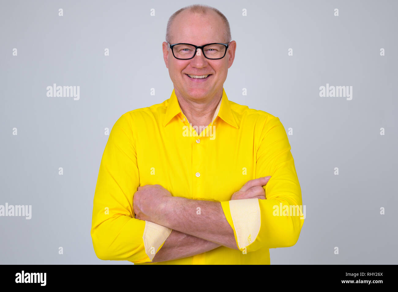 Portrait of happy handsome senior businessman smiling with arms crossed ...