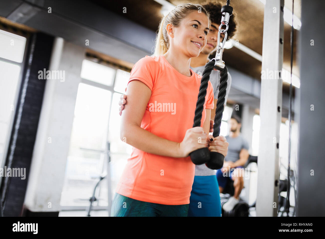 Young beautiful woman doing exercises with personal trainer Stock Photo