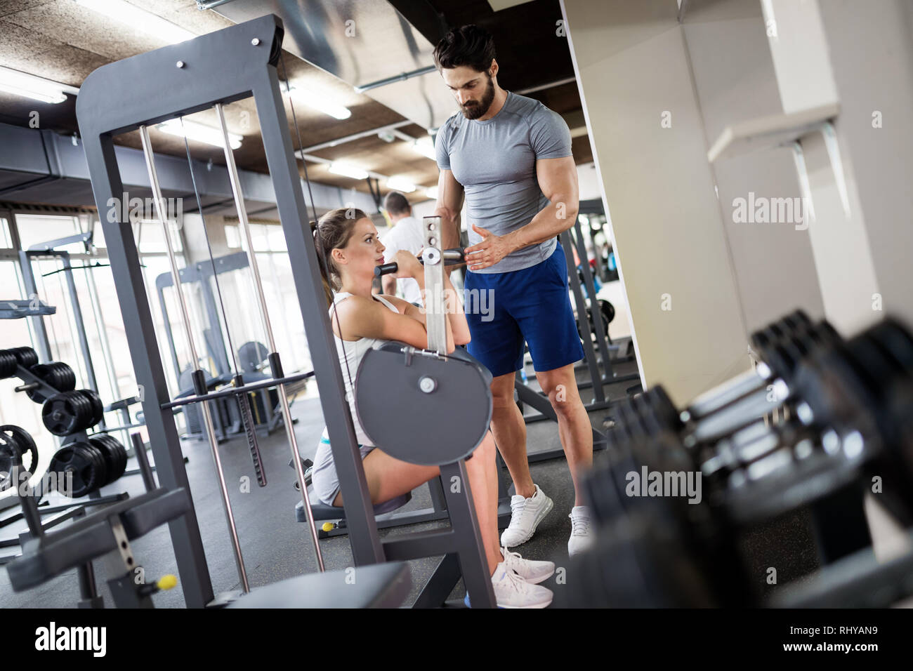 Young beautiful woman doing exercises with personal trainer Stock Photo