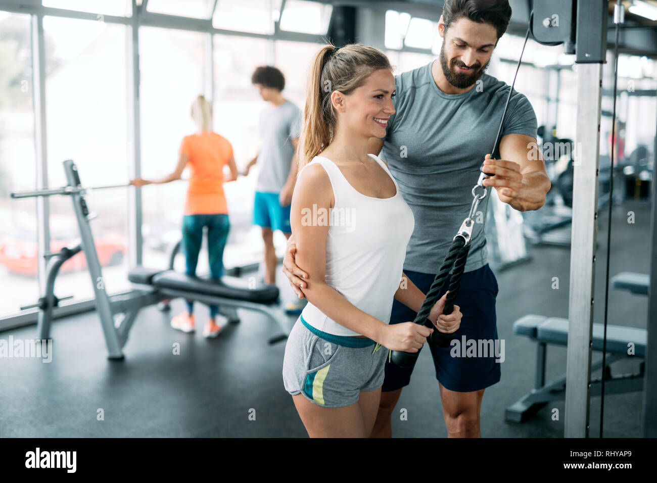 Young beautiful woman doing exercises with personal trainer Stock Photo