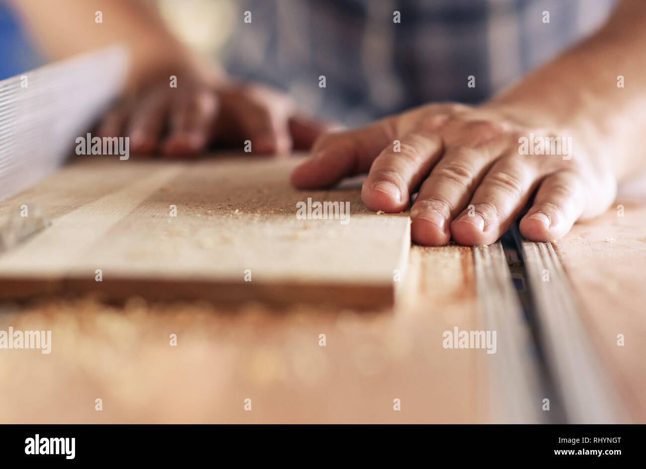 Craftsman sawing planks of wood in his carpentry workshop Stock Photo