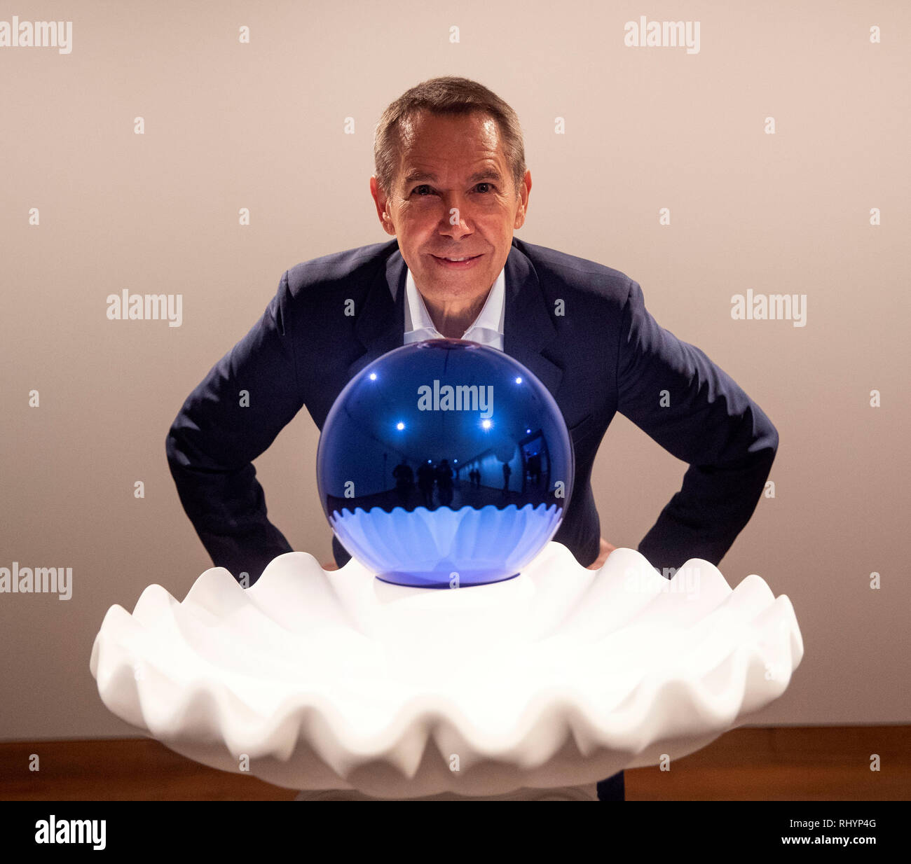 Artist Jeff Koons poses next to his piece called Gazing Ball (Birdbath