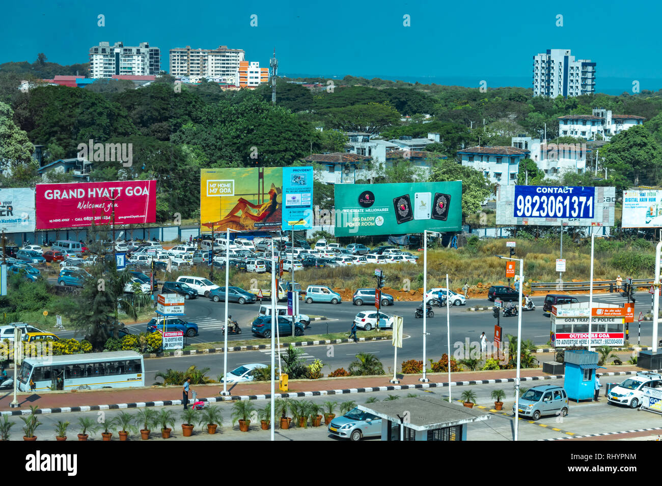 Busy junction, peak hour traffic, near Goa International Airport of Dabolim. Surrounding space being used commercially, covered with advert. hoardings Stock Photo