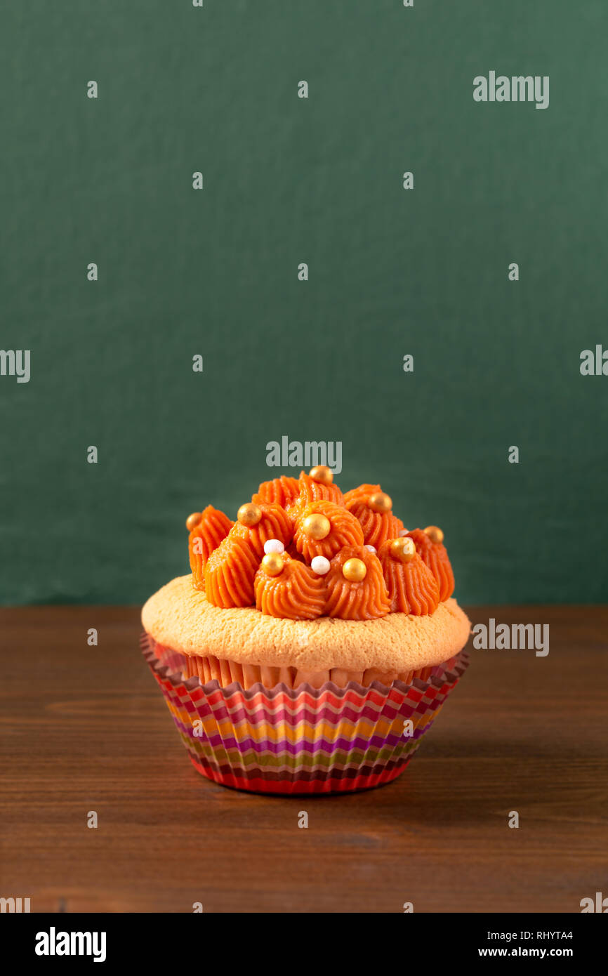 Homemade food Thai ice tea cupcake on wooden board and green background with copy space Stock Photo