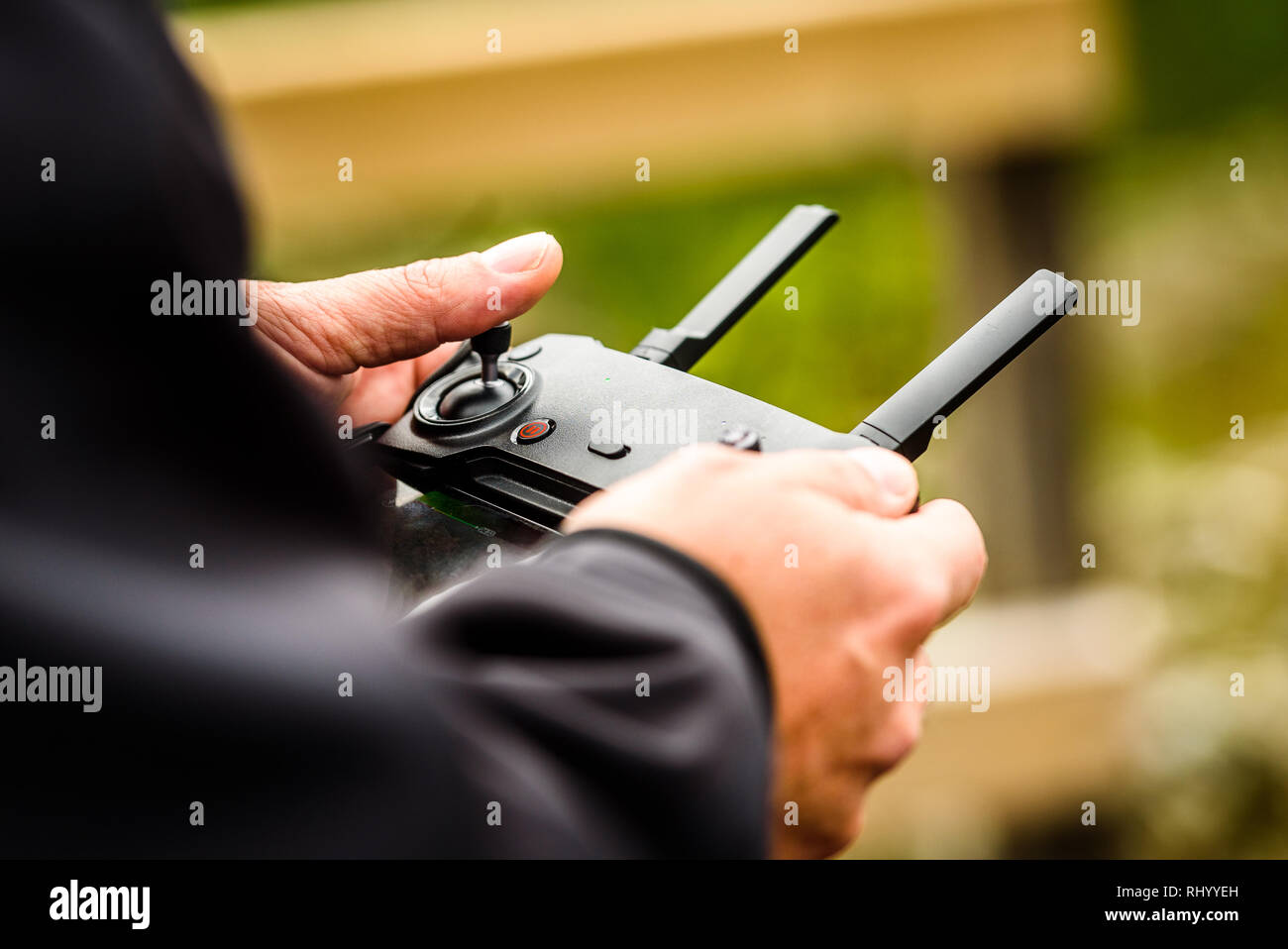 Hand holding drone quadcopter UAV remote control console controls