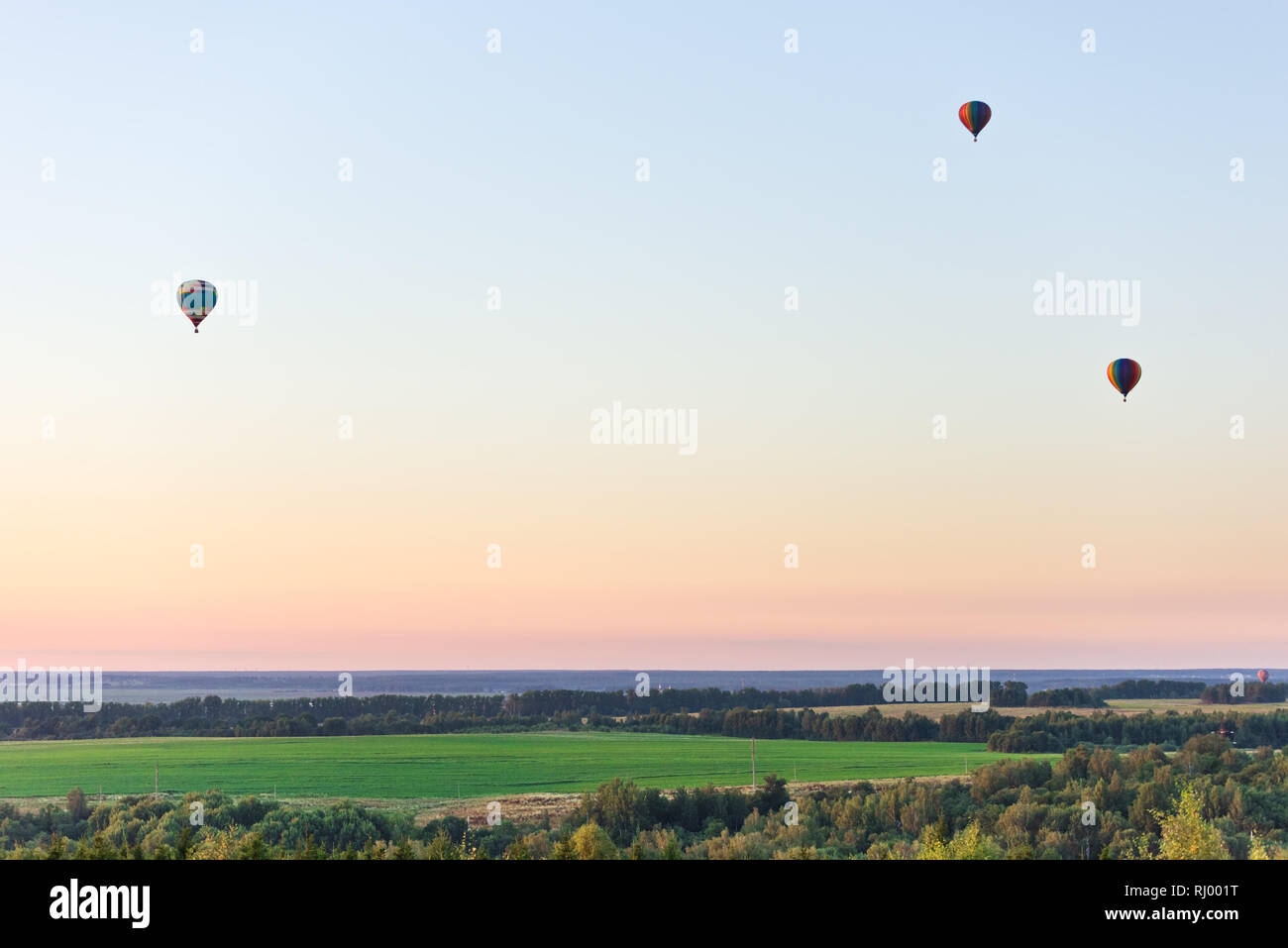Flying in a balloon. Three objects in the air against a cloudless sky. Evening landscape Stock Photo