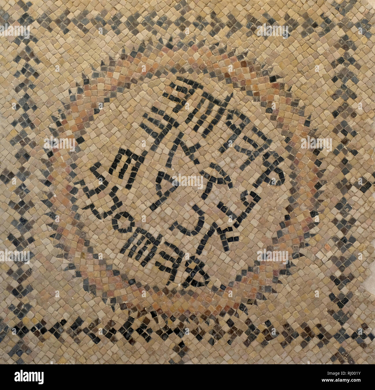 Section of a Byzantine-period (6th century) CE mosaic floor found in a side room of the northern synagogue complex in Beit Shean. The inscription, in Greek transliterated into Samaritan characters, reads: 'God help Afri and Anan.' The use of Samaritan script may indicate that the synagogue was a Samaritan one. Israel Stock Photo
