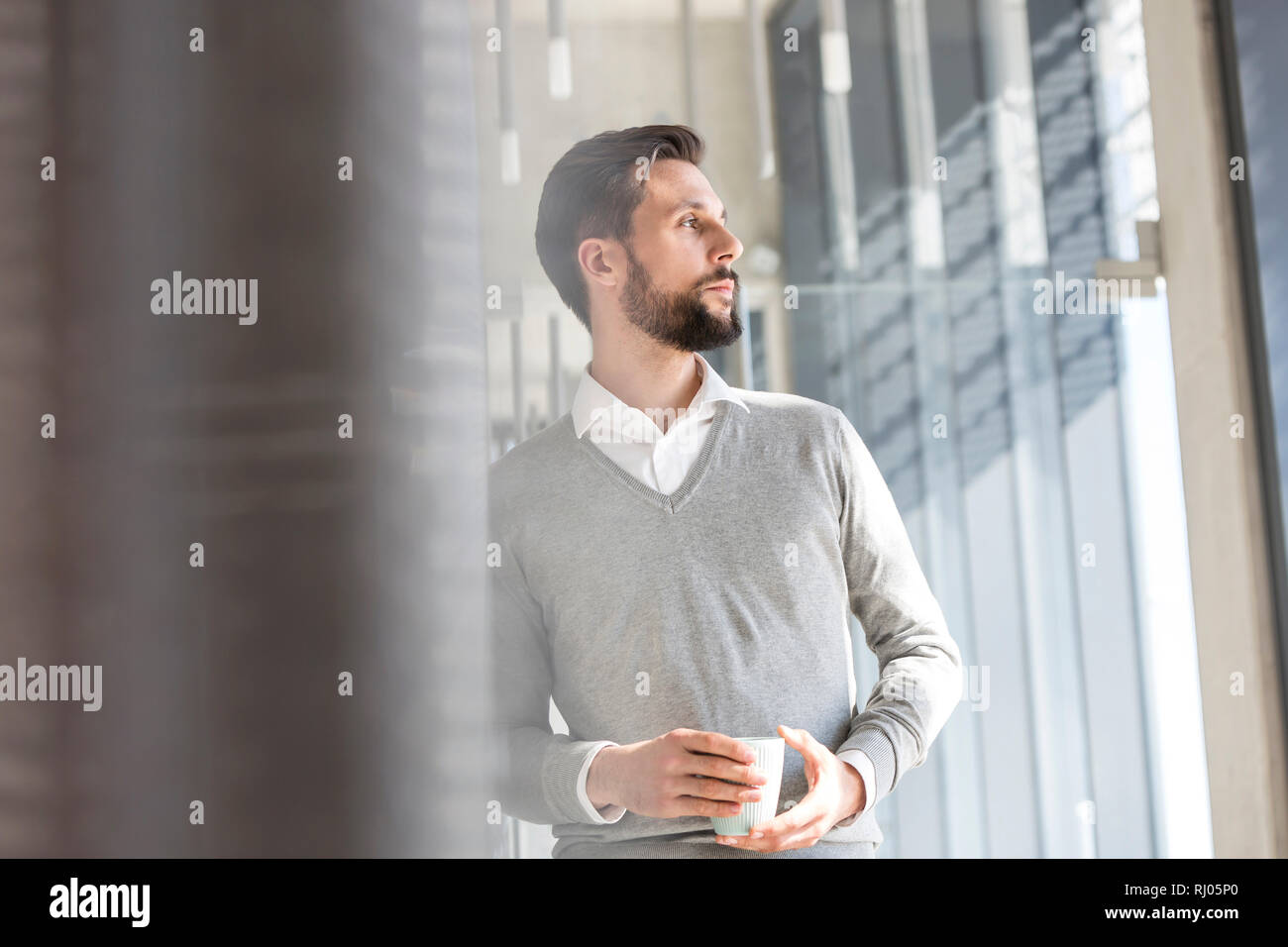 Thoughtful businessman having coffee in office Stock Photo