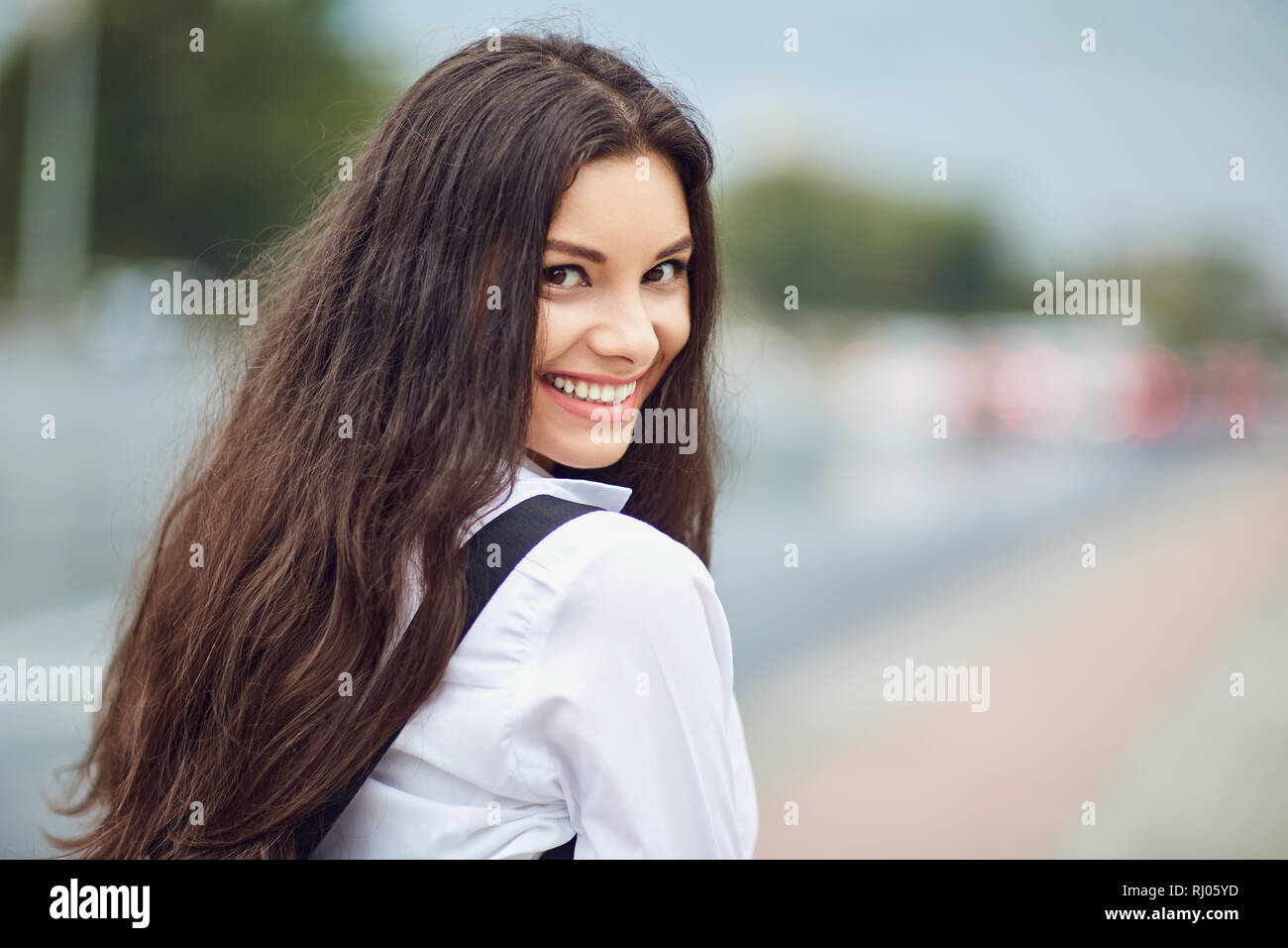 Beautiful happy brunette woman smiling outdoors on city street.  Stock Photo