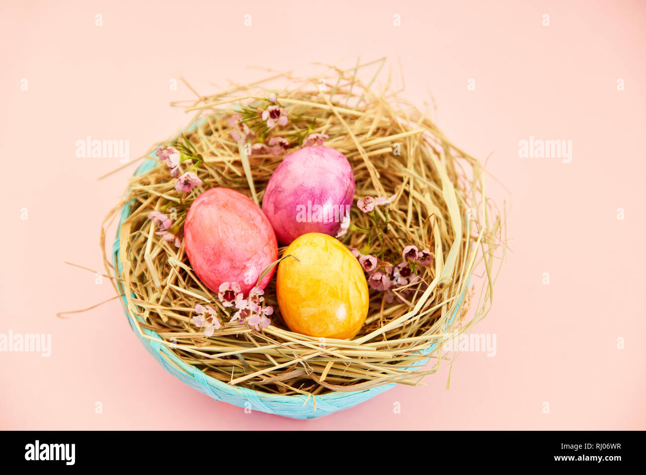 Three brightly painted easter eggs in the nest as easter decoration Stock Photo