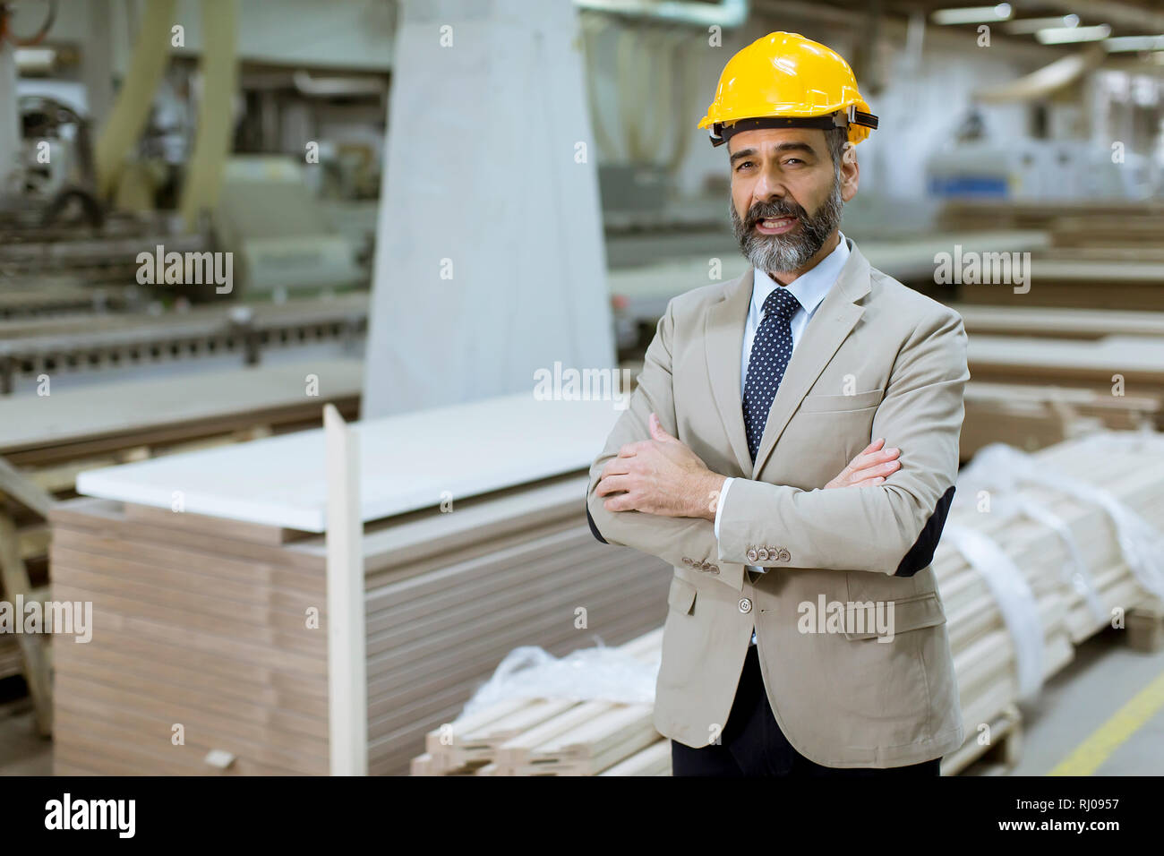 Portrait of senior handsome businessman in suit with helmet in a ...