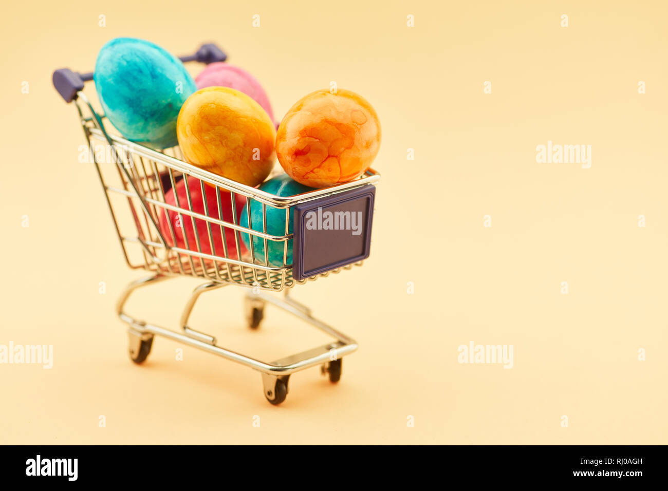 Easter shopping concept with shopping cart full of colorful easter eggs Stock Photo