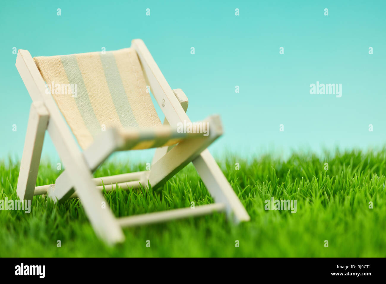 Deck chair for relaxation during the summer holidays on a green meadow Stock Photo