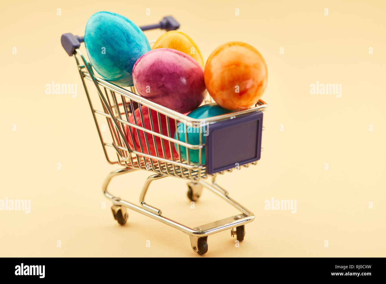 Shopping colorful easter eggs in shopping cart for easter Stock Photo