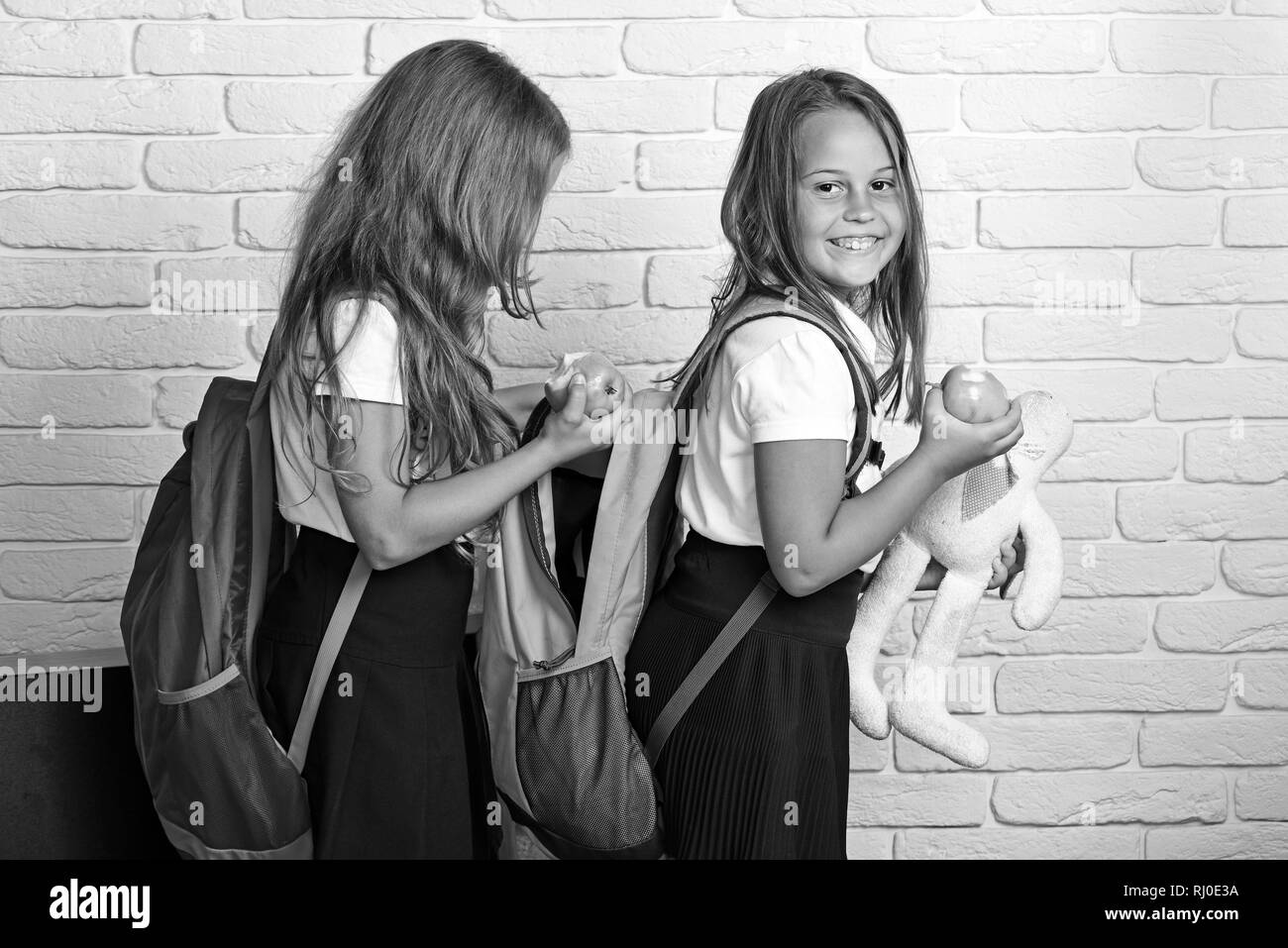 education of children and people concept - happy kids or students with book in backpack. Stock Photo