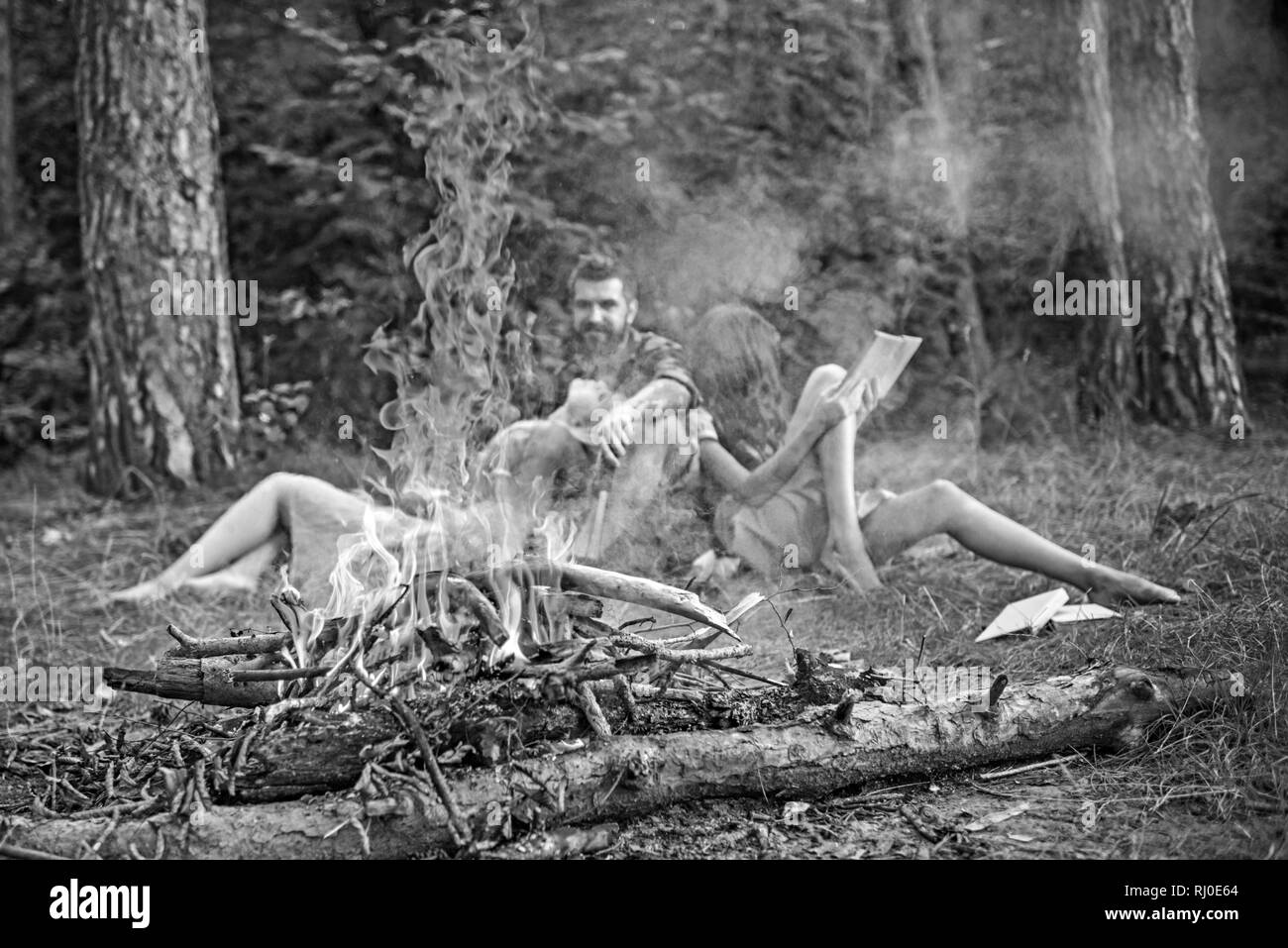 Bonfire flame with sparks and people on background. Fire burn in camp