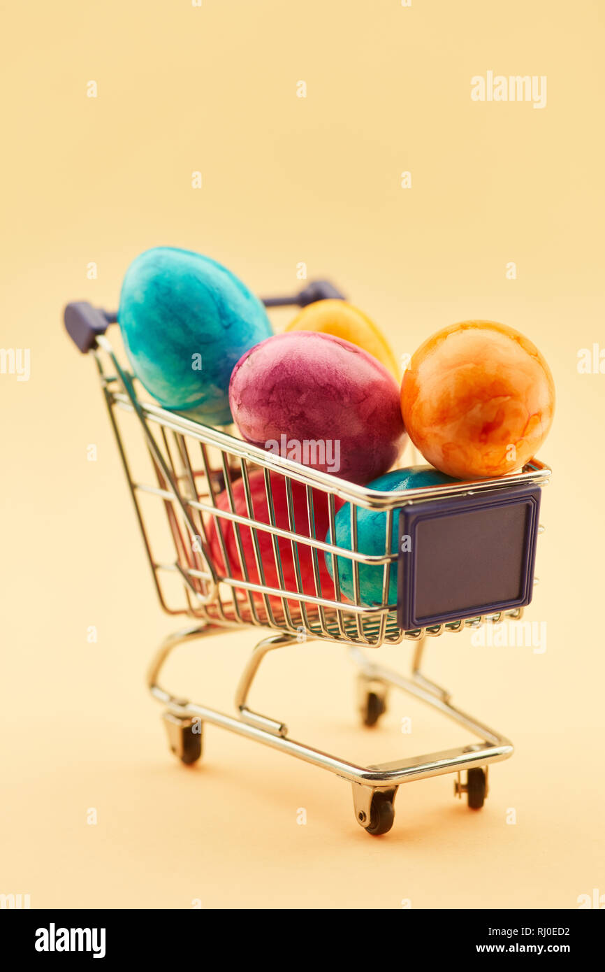 Colorful easter eggs in shopping cart in supermarket before easter Stock Photo