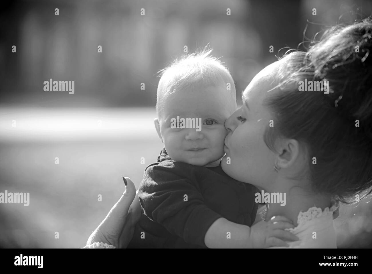 Woman kiss child with love. Mother and little son. Mom and baby boy outdoor. Mothers day concept. Happy family enjoy sunny day. Love care and trust Stock Photo