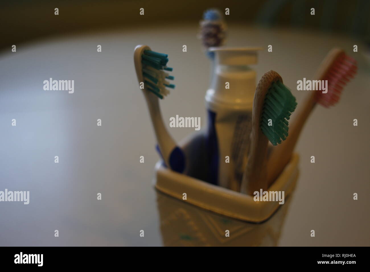 Tooth brushes in glass holder Stock Photo Alamy