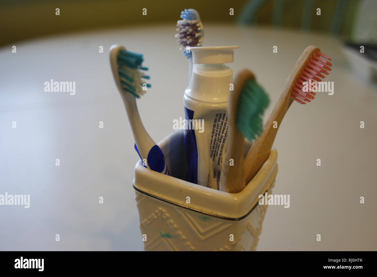 Tooth brushes in glass holder Stock Photo Alamy