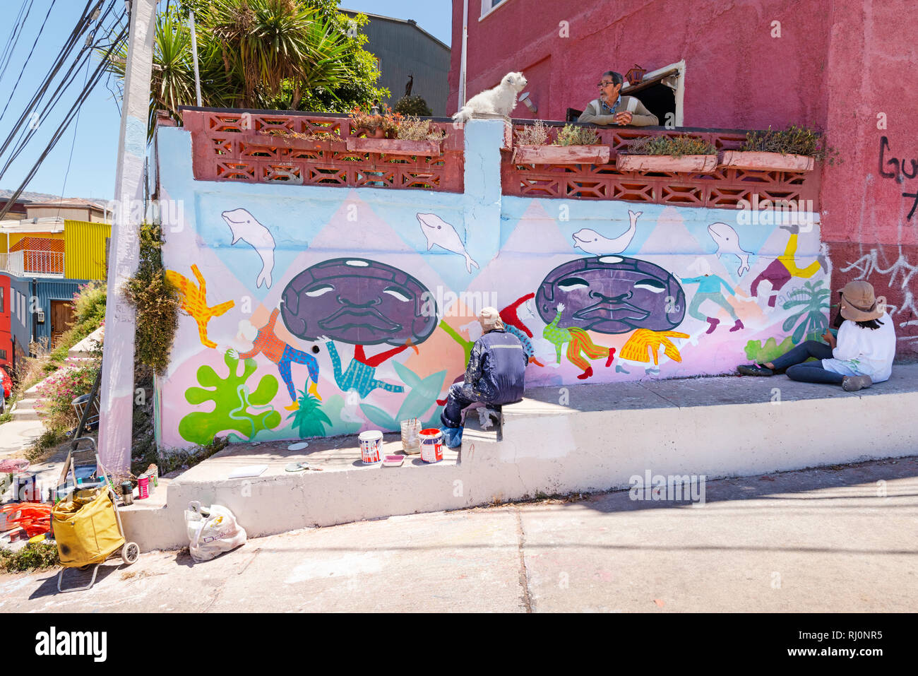 Street artists painting a wall in Valparaiso, Chile. Stock Photo