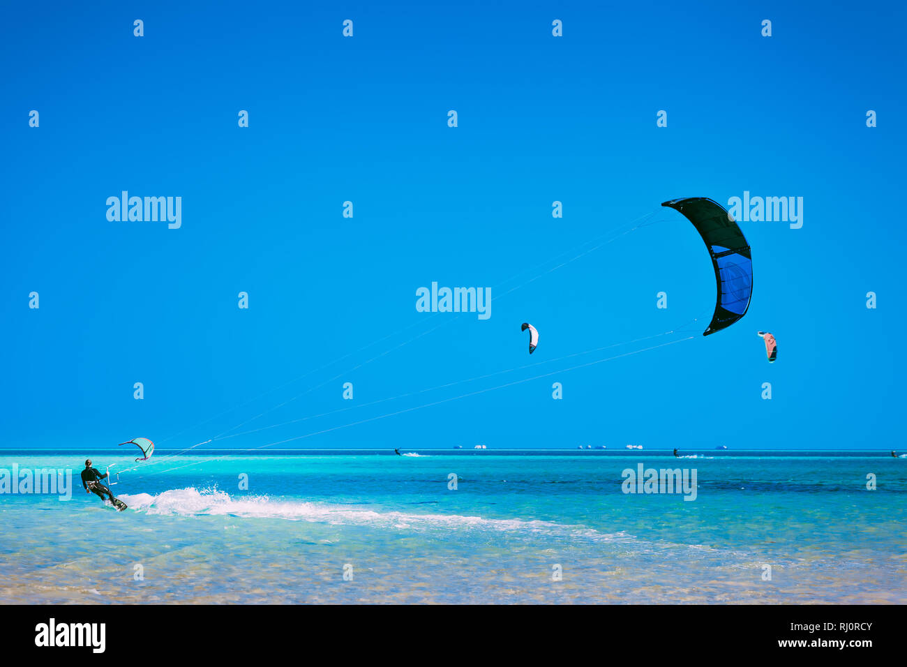 Egypt, Hurghada - 30 November, 2017: The kiter gliding over the Red sea surface. The active leisure. Picturesque marine scenery. The popular tourist water attraction. The outdoor sport activity. Stock Photo
