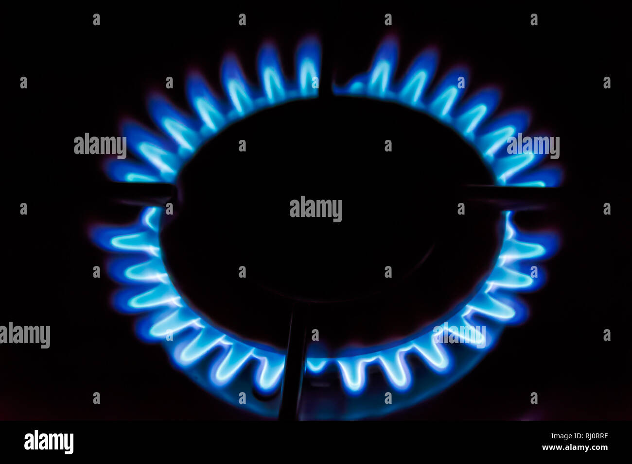 Gas burning on the stove. Blue flame of gas on a dark background Stock