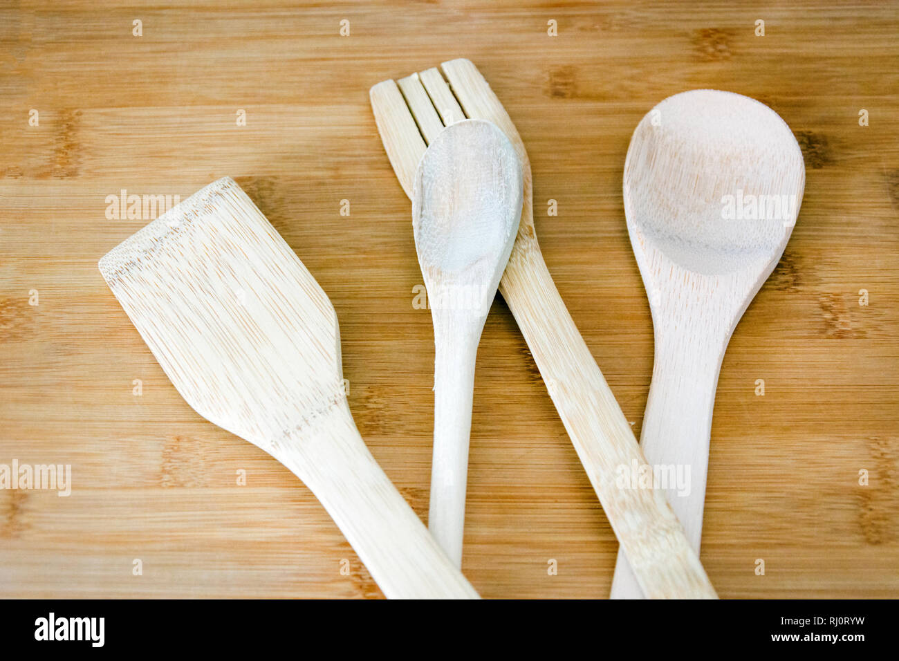 Close up of a group of wooden kitchen utensils on a wooden table Stock Photo