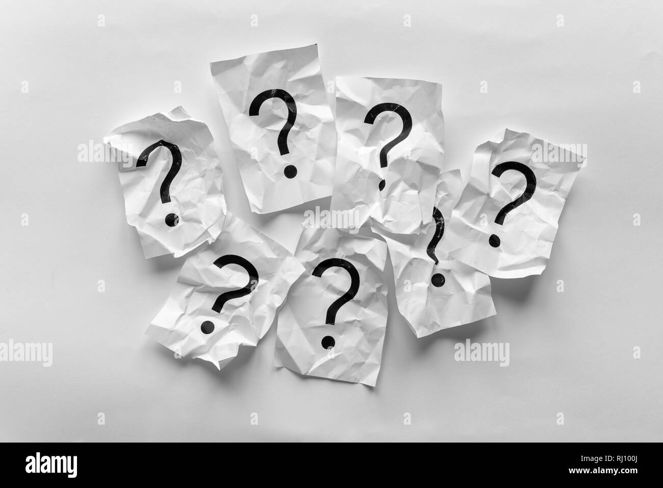 Border of crumpled question marks on cards over a white background with copy space in a conceptual image Stock Photo