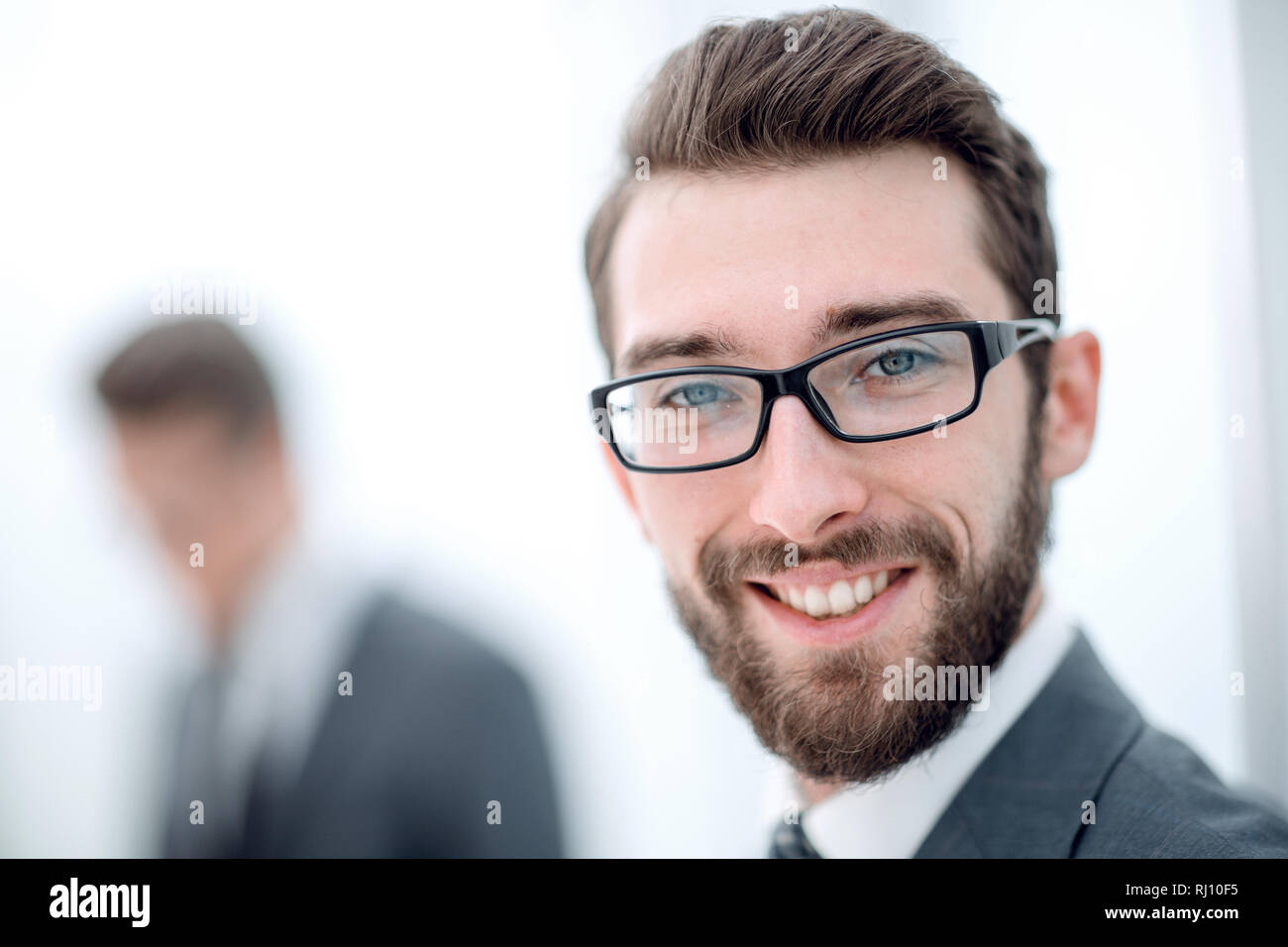close up.smiling businessman in the office background Stock Photo - Alamy