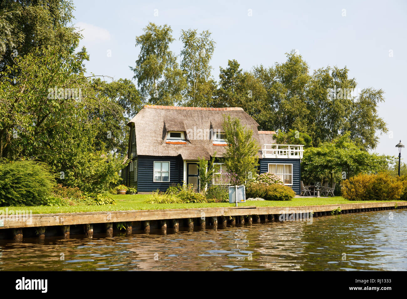 The thatched roof house with beatiful garden in fairytale village Giethoorn in The Netherlands. Stock Photo