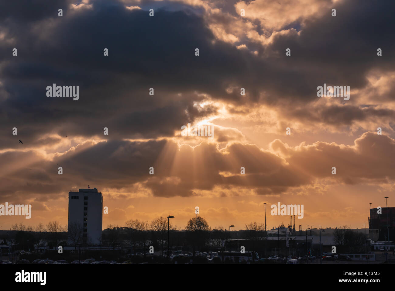 Dramatic sky with rays of sun over city Stock Photo