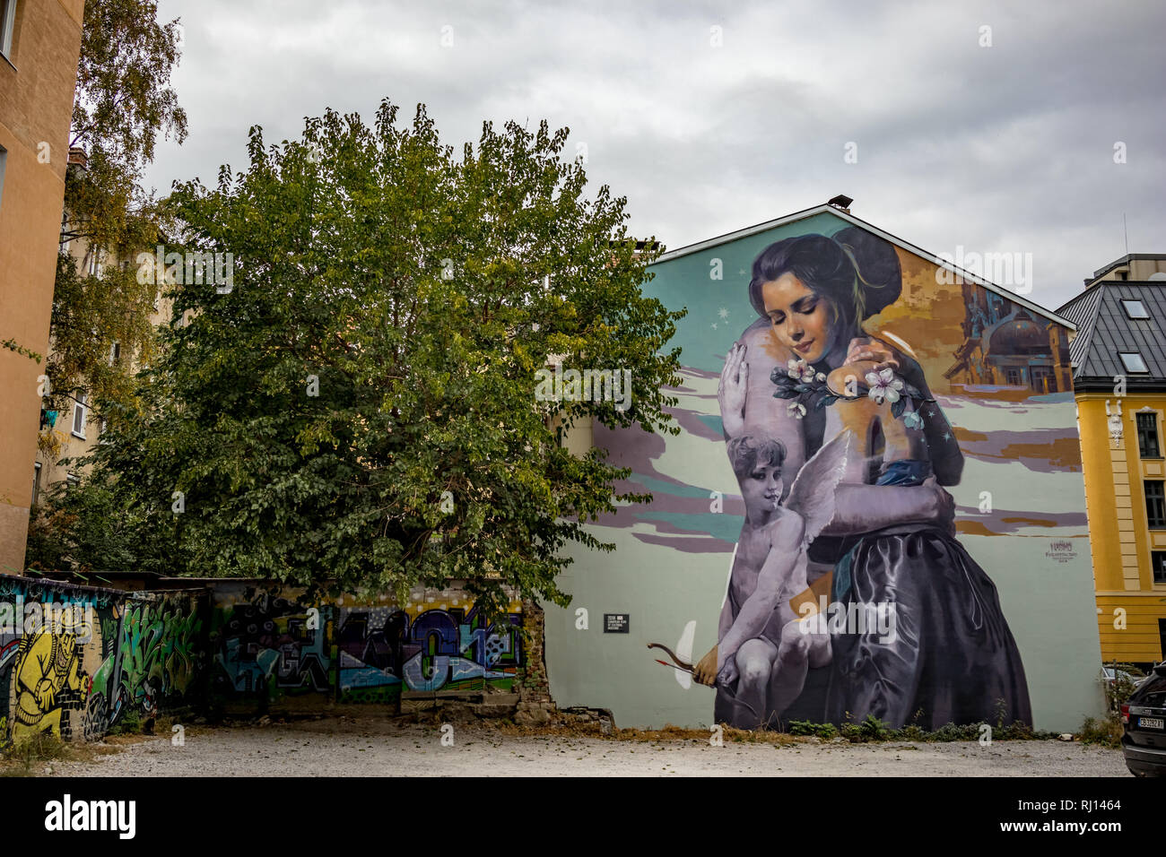 SOFIA, BULGARIA - OCTOBER 14, 2018: Backyard, car parking space has its walls painted with graffiti by several artists, central part of Bulgarian capital. Moody cloudy autumn afternoon Stock Photo