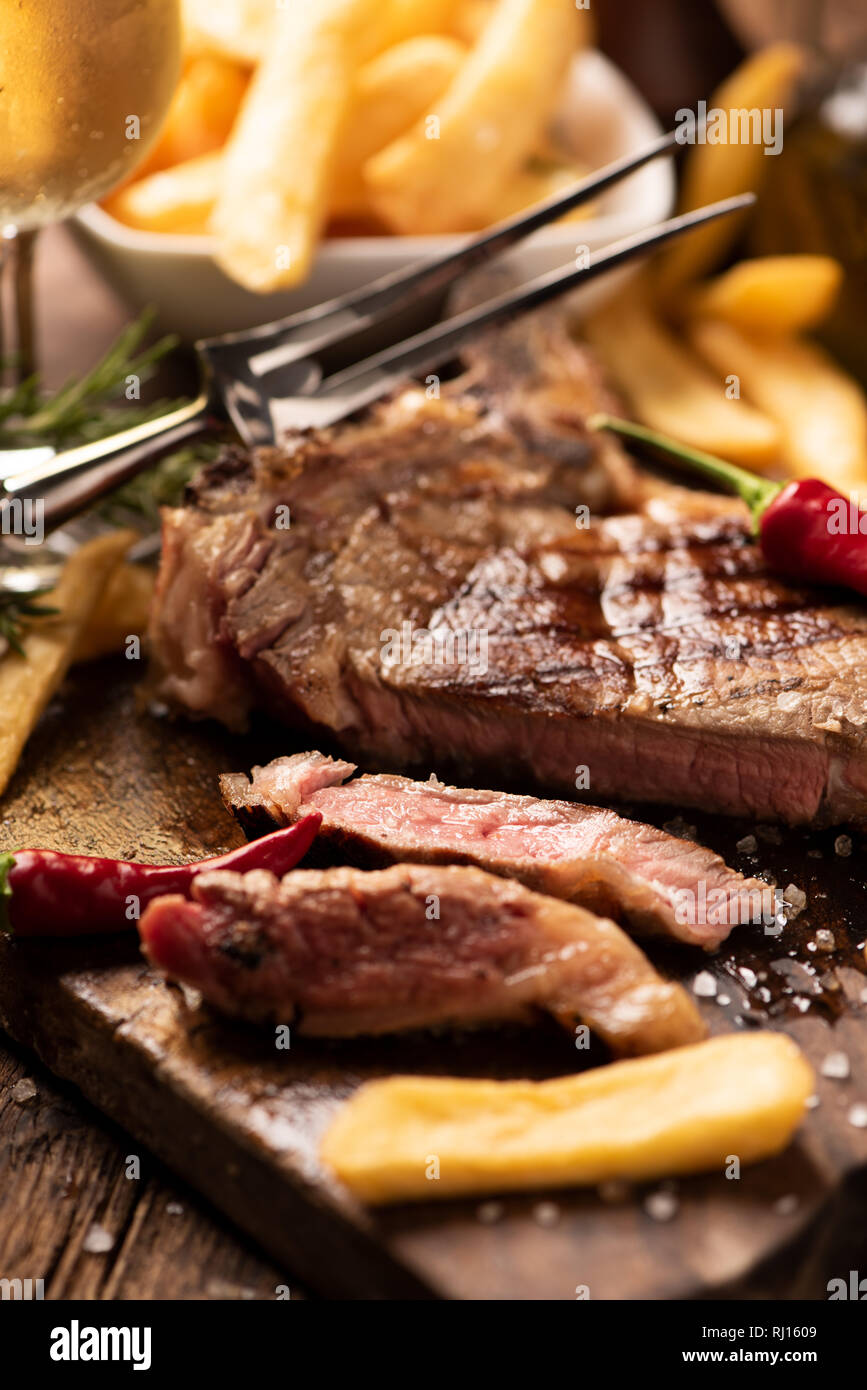Grilled rib fillet steak with fried chips ready to serve Stock Photo ...