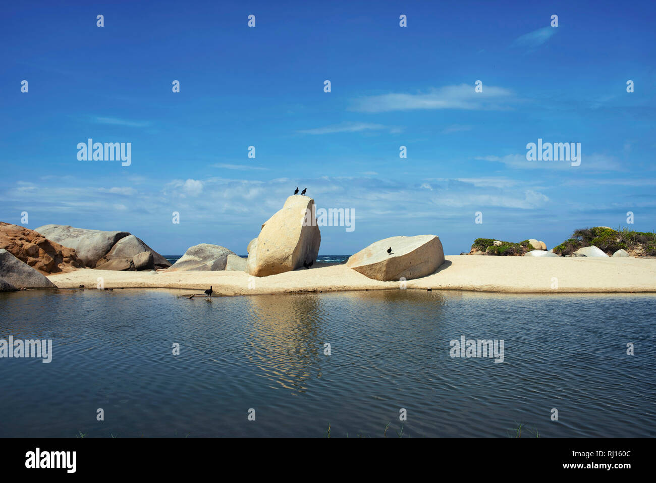 Coastal lagoon with minimalistic rock formations and birds. Arrecifes Beach, Tayrona Park, Colombia. Sep 2018 Stock Photo