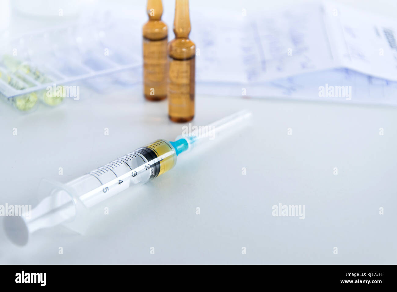 Medical syringe with injection solution, medicine pills and capsules on ...