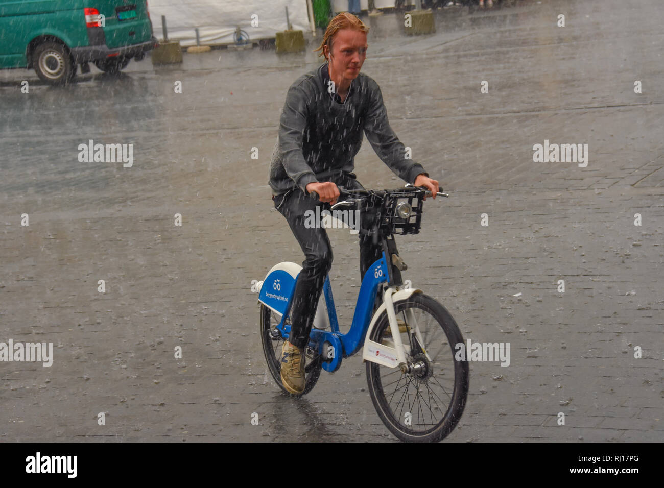 Riding a bicycle in the rain, Bergen Norway Stock Photo