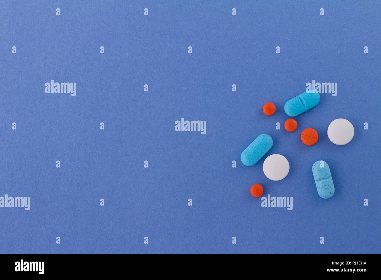 Pills of colors on neutral background of celestial color. Drugs for use in humans. Stock Photo