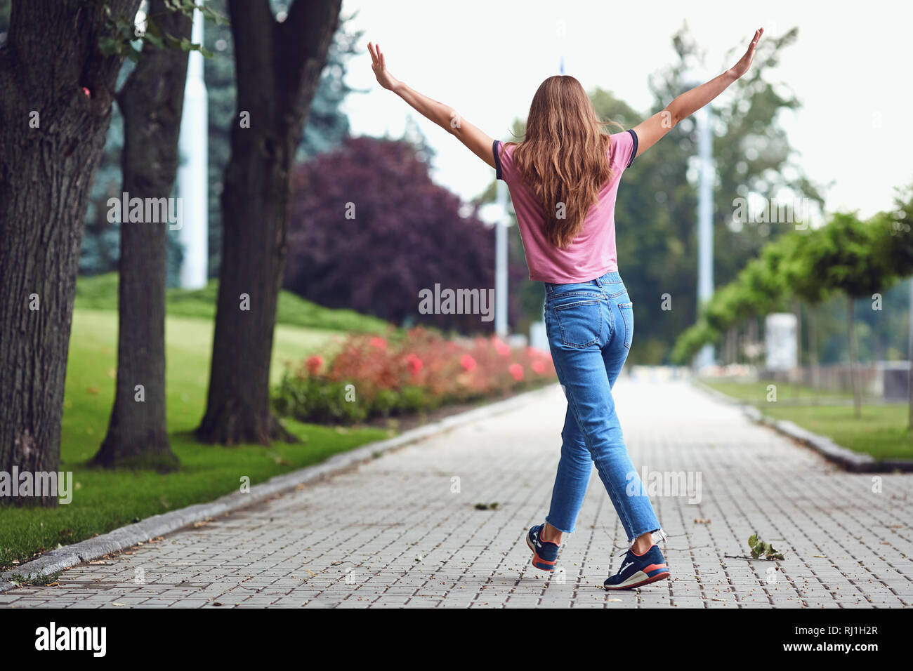 Rear view of a happy woman walking during on the streets Stock Photo ...