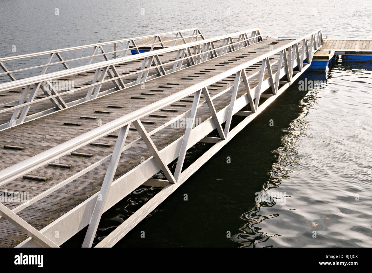 Modern wooden jetty or pier with metal sides without people or boats. Boat ramp and pier Stock Photo