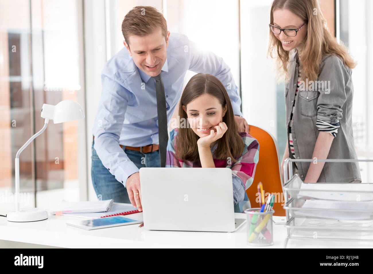 Creative business colleagues using laptop in office Stock Photo