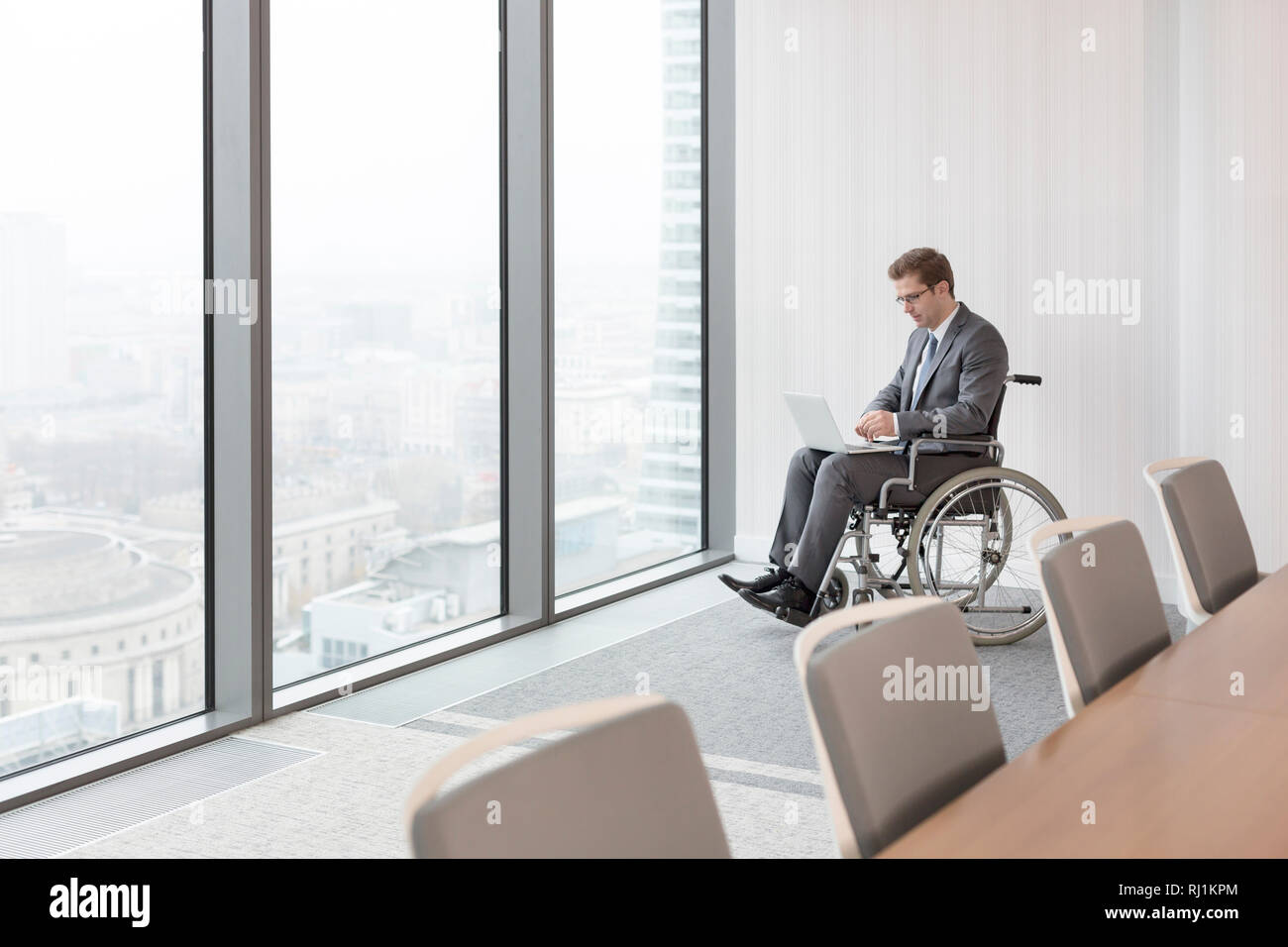 Disabled businessman using laptop in boardroom at modern office Stock Photo
