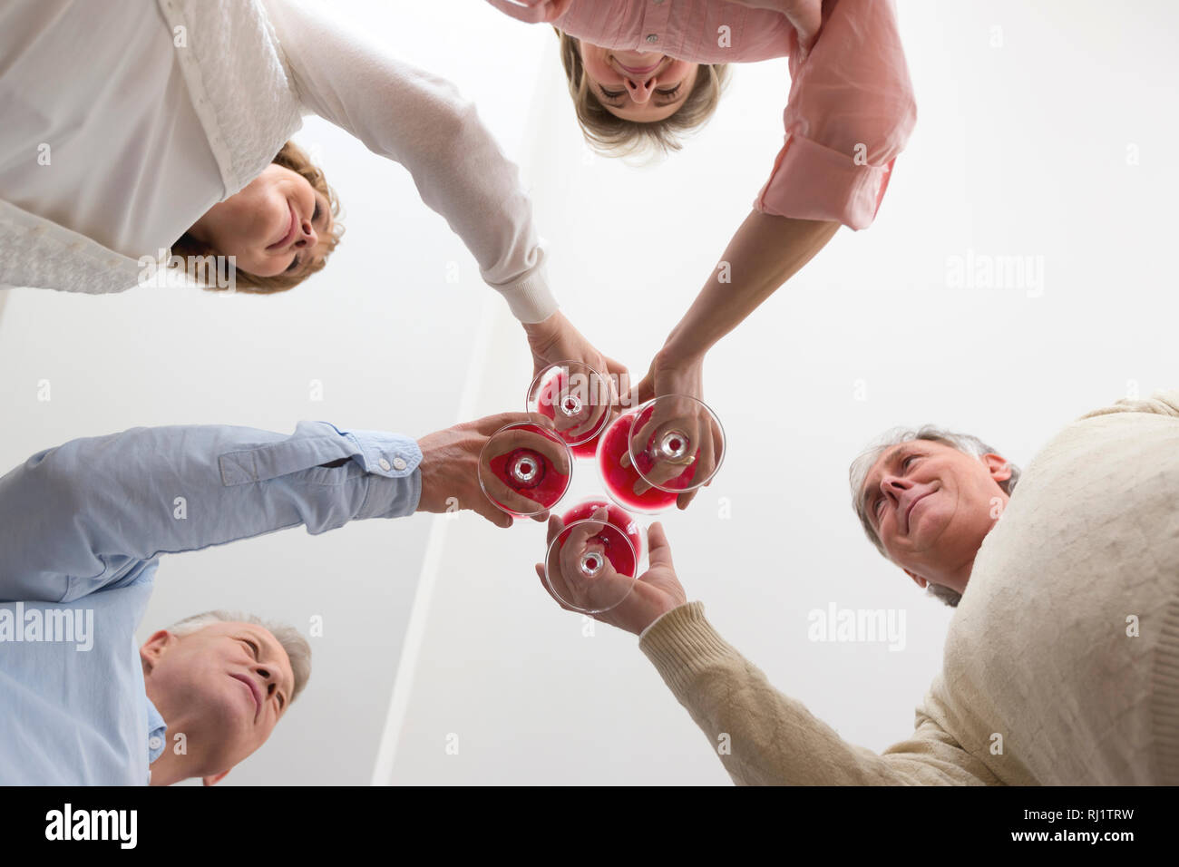 Directly below view of mature friends toasting wineglasses at home Stock Photo