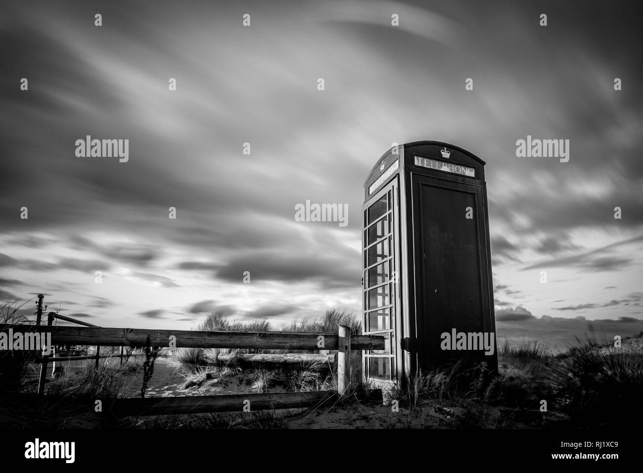 Traditional phone box on sandy coastal point, black & white Stock Photo ...