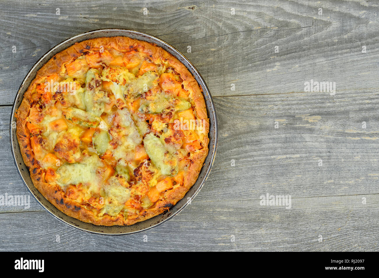 Pie with vegetables and cheese in the pan on a vintage grey wood rustic background Stock Photo