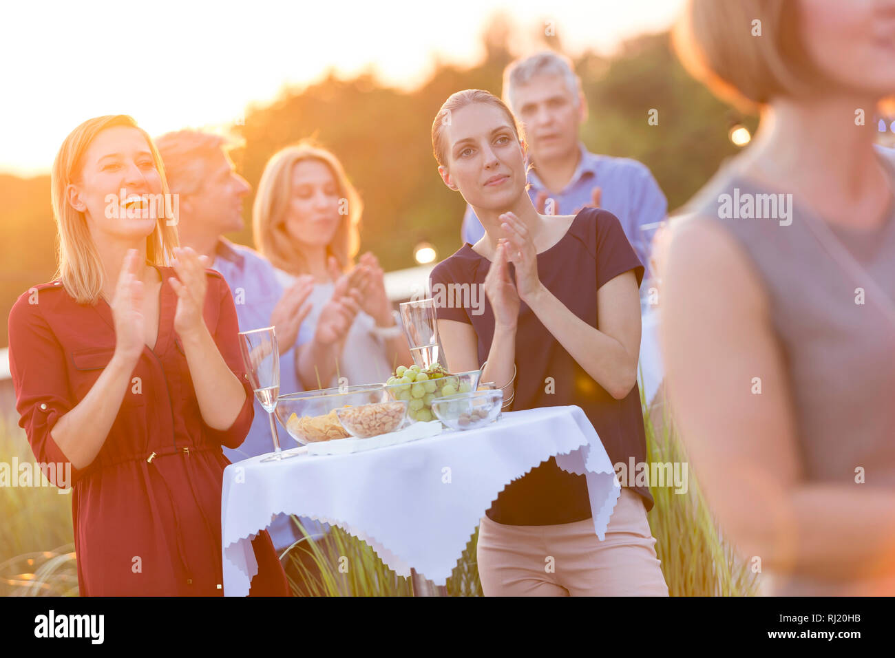 Business colleagues applauding during rooftop success party Stock Photo