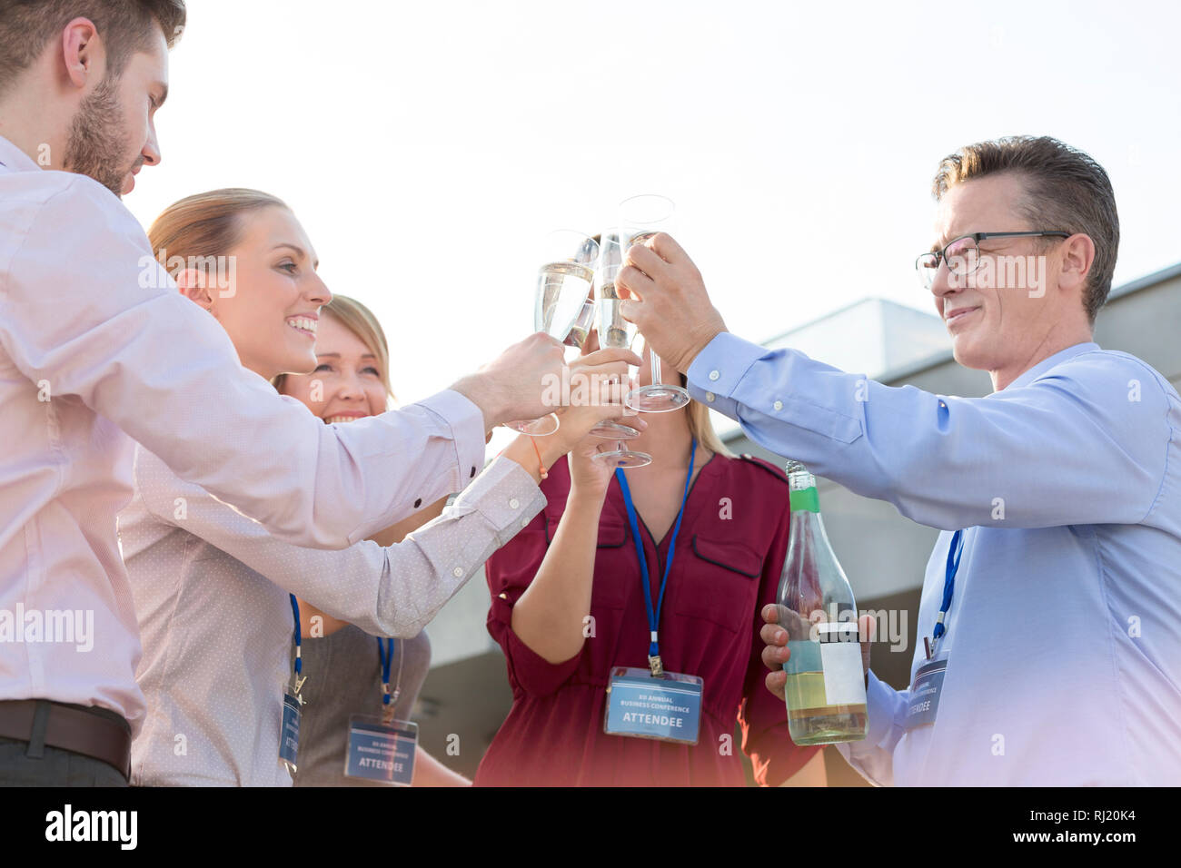 Business colleagues toasting wineglasses during rooftop success party Stock Photo