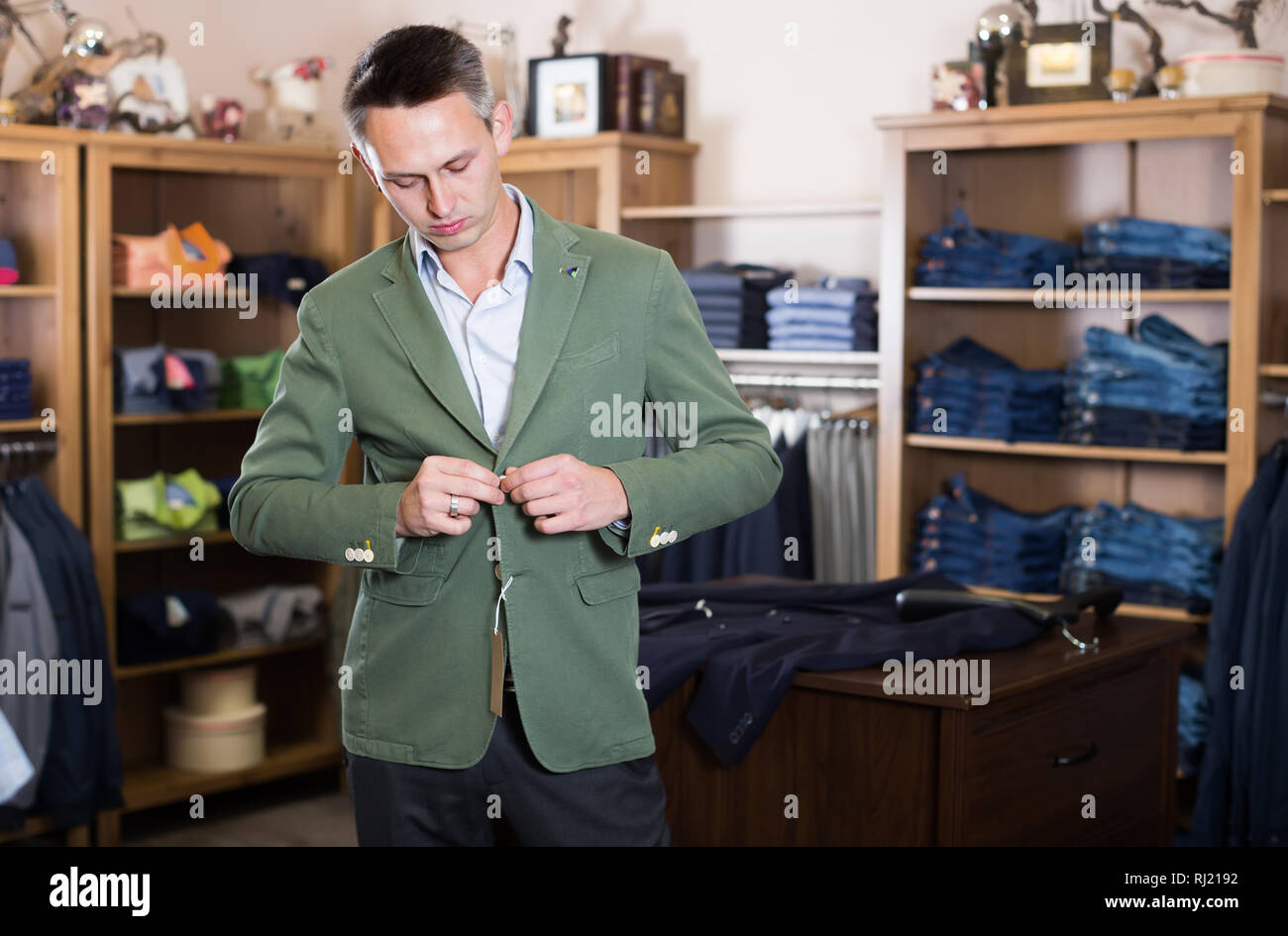 Young man customer choosing fashion suit in men’s store Stock Photo - Alamy