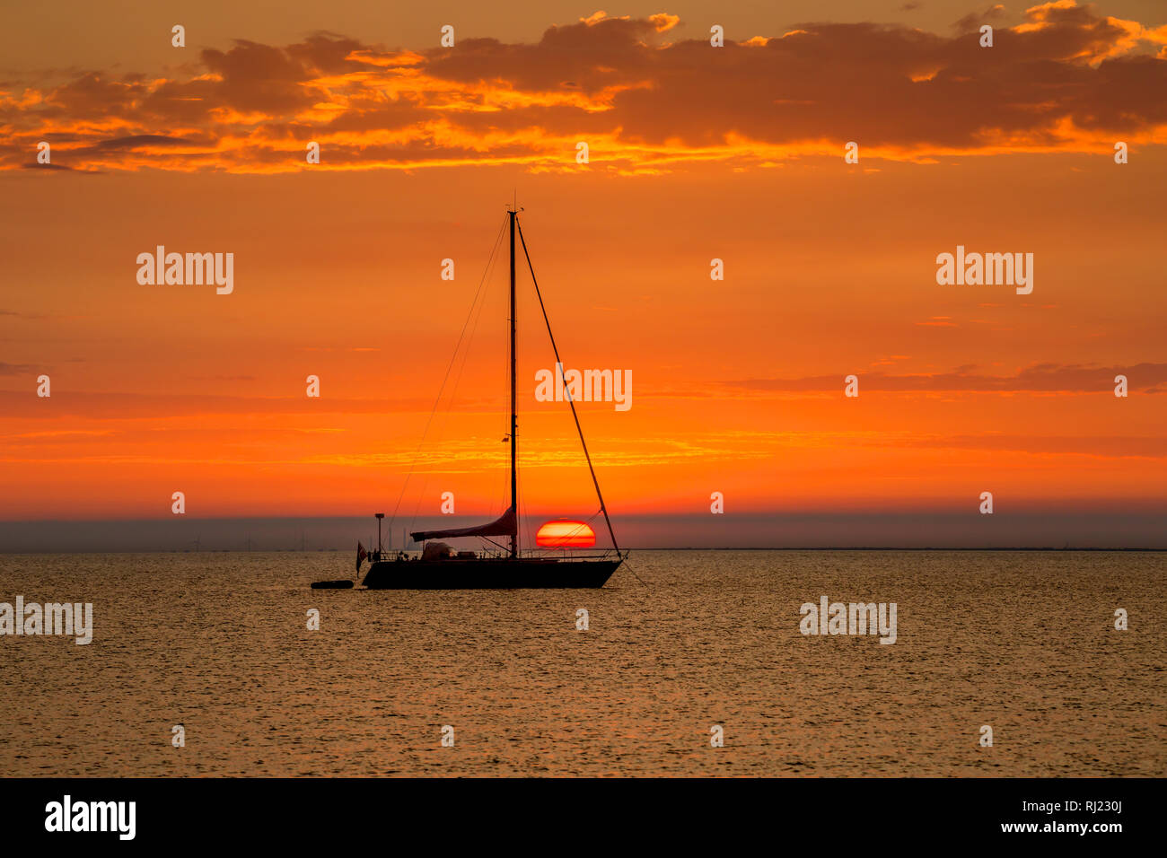 Sailboat At Anchor With Beautiful Sunset In The Background Stock Photo Alamy