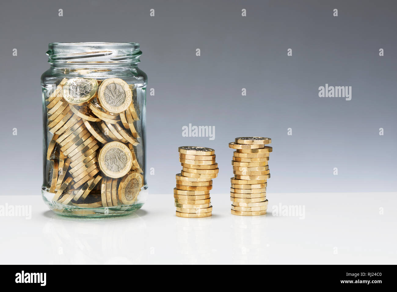 Glass Savings Jar with One Pound Coins Stock Photo